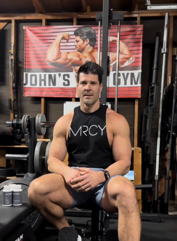John Prather, health and fitness professional, in his gym holding partiQlar supplements.